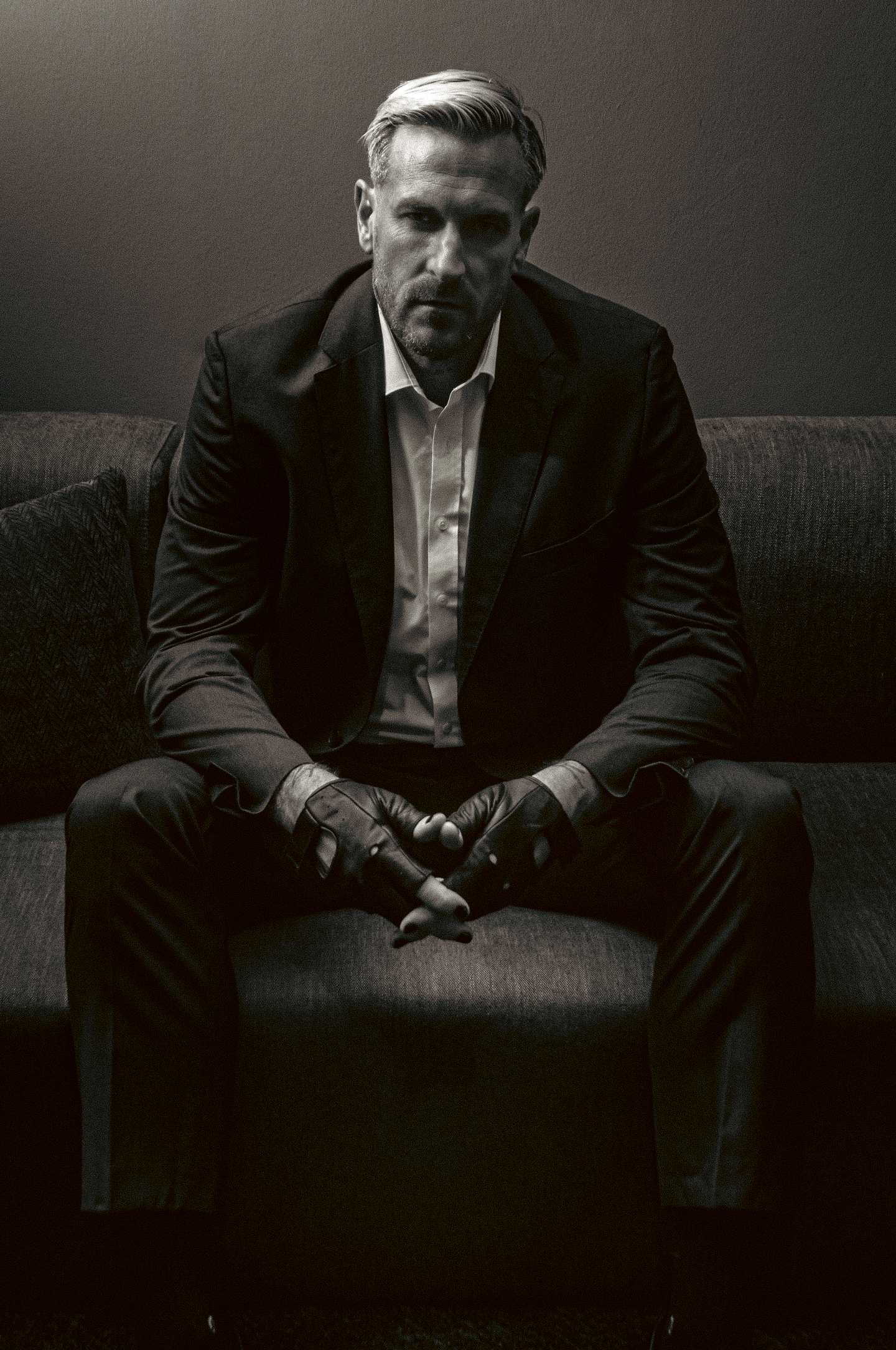 Kevin standing in profile, tailored shirt, contemplative