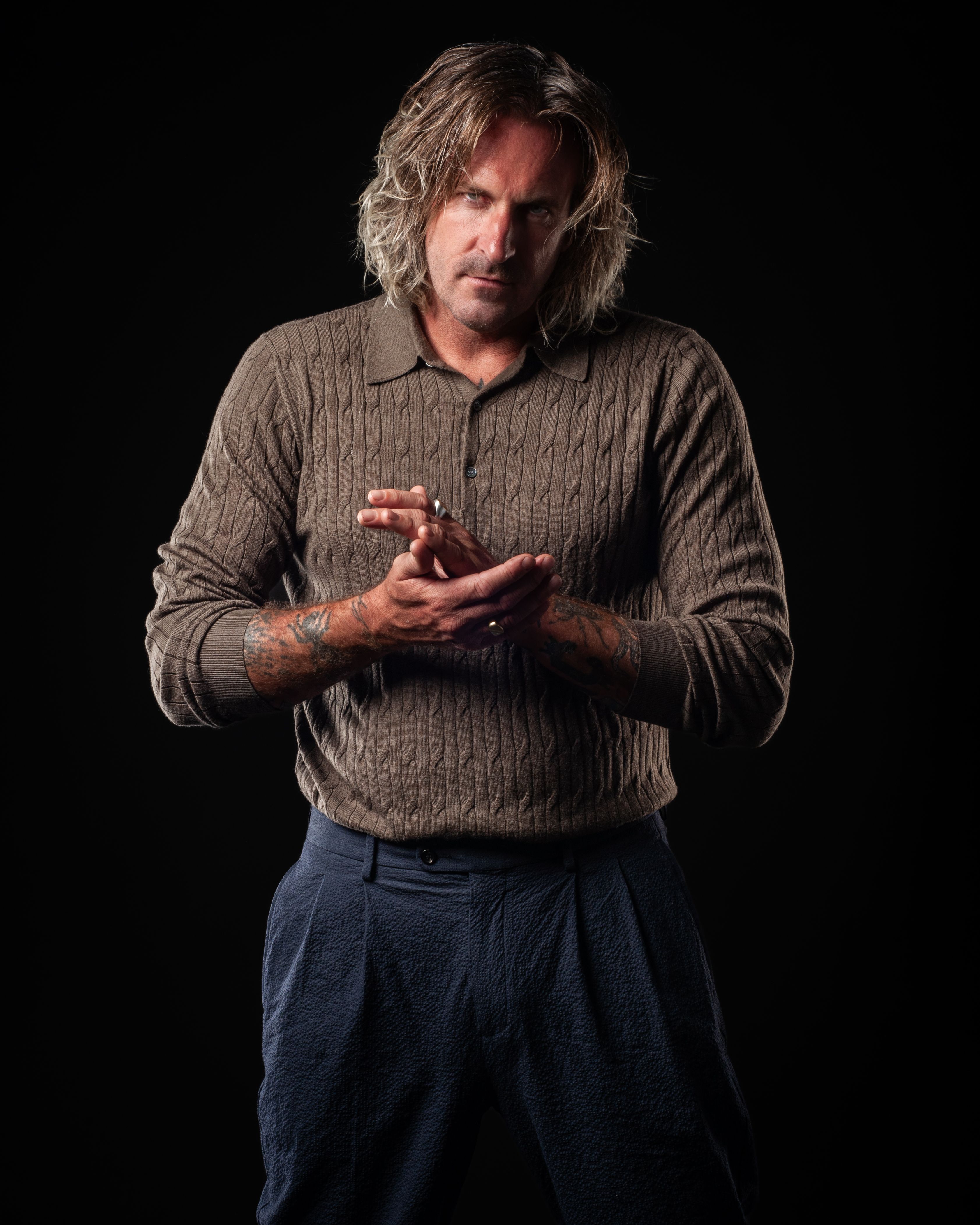 Kevin in three-quarter view, hands resting, quiet expression