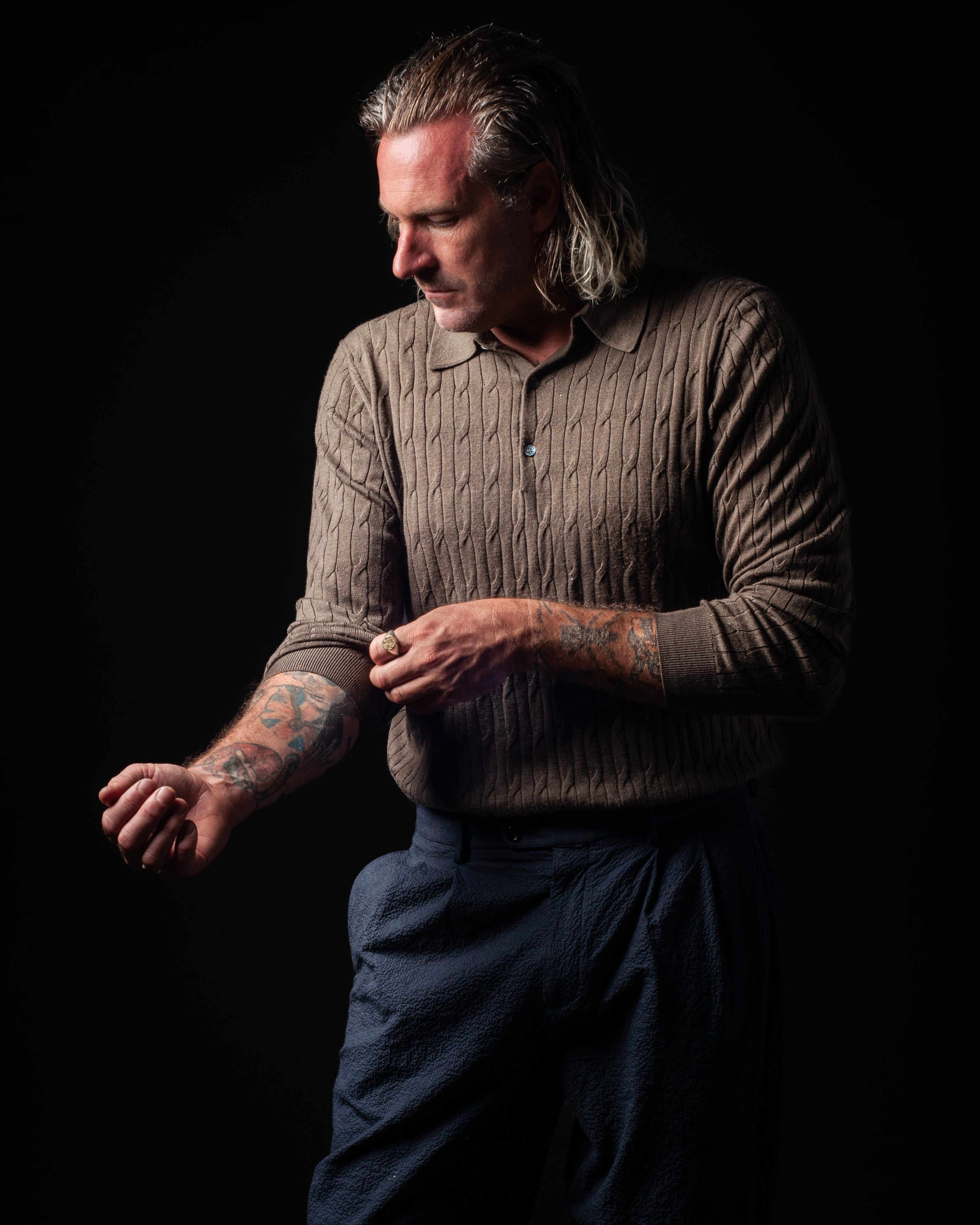 Kevin in three-quarter view, tradesman's hands resting, calm