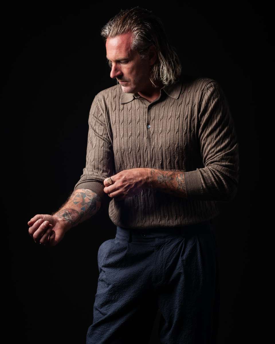 Kevin in three-quarter view, tradesman's hands resting, calm